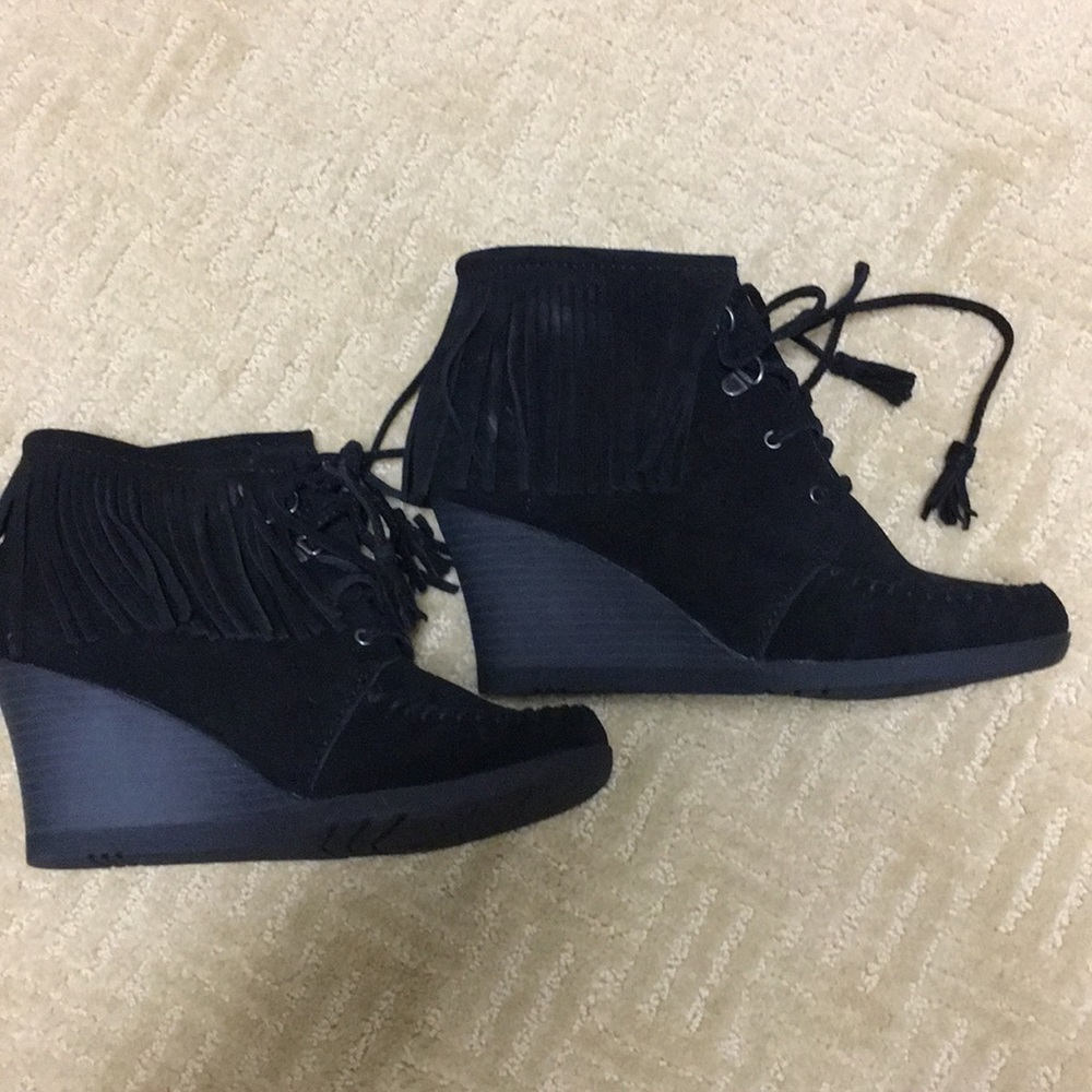 Brand new Minnetonka black squeeze fringe wedge